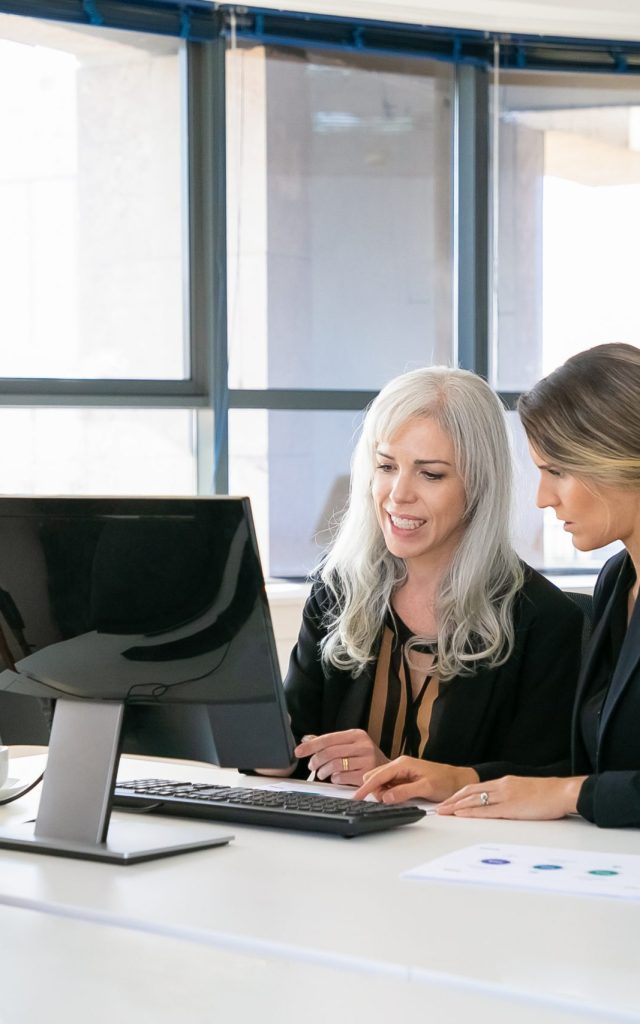Female colleagues sitting at workplace together mentorias